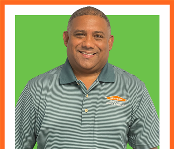 Julio, male, SERVPRO employee, cut out, against a white background, SERVPRO green sign above head
